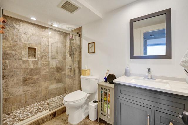 A bathroom features a glass-enclosed stone shower, a white toilet, and a dark gray vanity — 401 NE 14th Avenue # 705, FL 33009, FL