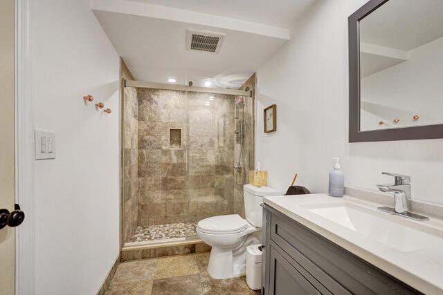 A bathroom featuring a glass-enclosed shower, a white toilet, and a gray vanity with sink — 401 NE 14th Avenue # 705, FL 33009, FL
