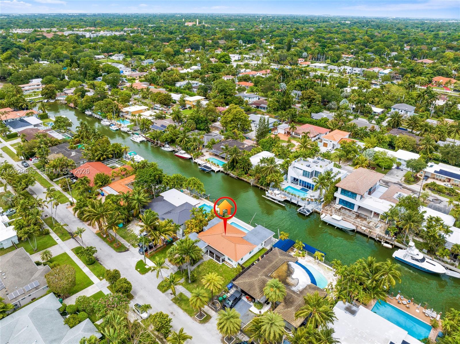 An aerial view shows a waterfront house with a red tile roof and pool — 1161 NE 86th St, Miami FL 33138, MIAMI, FL