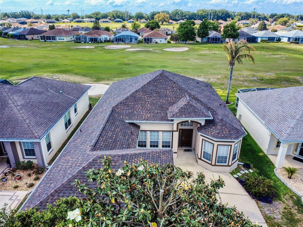 An aerial view shows a house with a shingled roof overlooking a golf course — 12066 SE 176 LOOP, SUMMERFIELD, FL