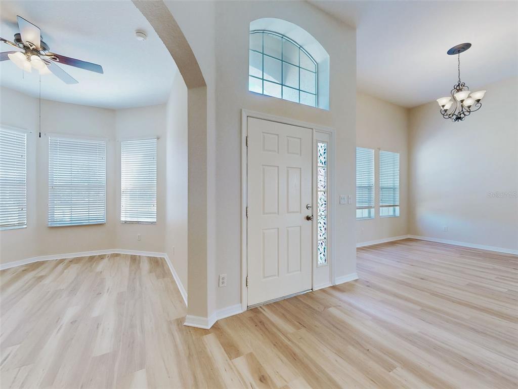 An entryway with light wood flooring, a white front door, and a decorative arched window — 12066 SE 176 LOOP, SUMMERFIELD, FL