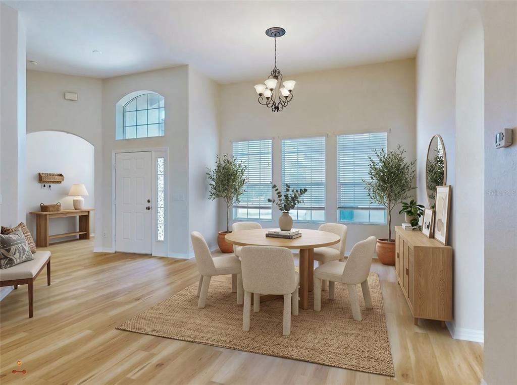 A dining area features a round wooden table, four upholstered chairs, and light wood flooring — 12066 SE 176 LOOP, SUMMERFIELD, FL