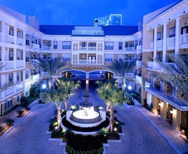 A swimming pool sits in the center of a courtyard surrounded by yellow apartment buildings — 860 N ORANGE AVENUE UNIT 464, ORLANDO, FL
