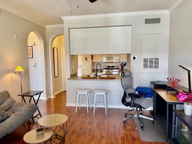 A living room features wood-look flooring, a television on a console, and a desk area — 860 N ORANGE AVENUE UNIT 464, ORLANDO, FL