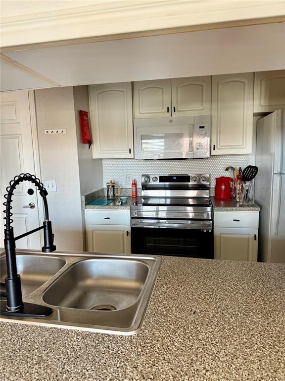 A living room with wood-look flooring, a kitchen pass-through, and a desk area — 860 N ORANGE AVENUE UNIT 464, ORLANDO, FL