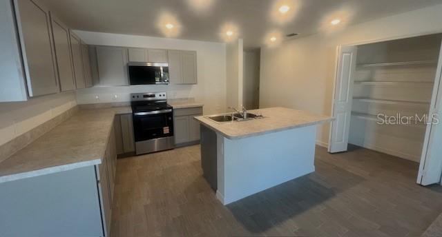A kitchen featuring gray cabinets, light countertops, a center island, and a walk-in pantry — 23190 VAN BUREN AVENUE, PORT CHARLOTTE, FL