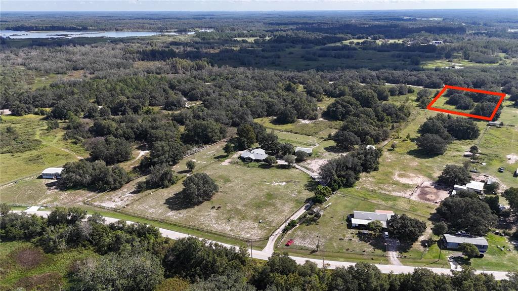 An aerial view shows a rural property with houses, pastures, and a red-outlined wooded lot — EVANS ROAD, POLK CITY, FL