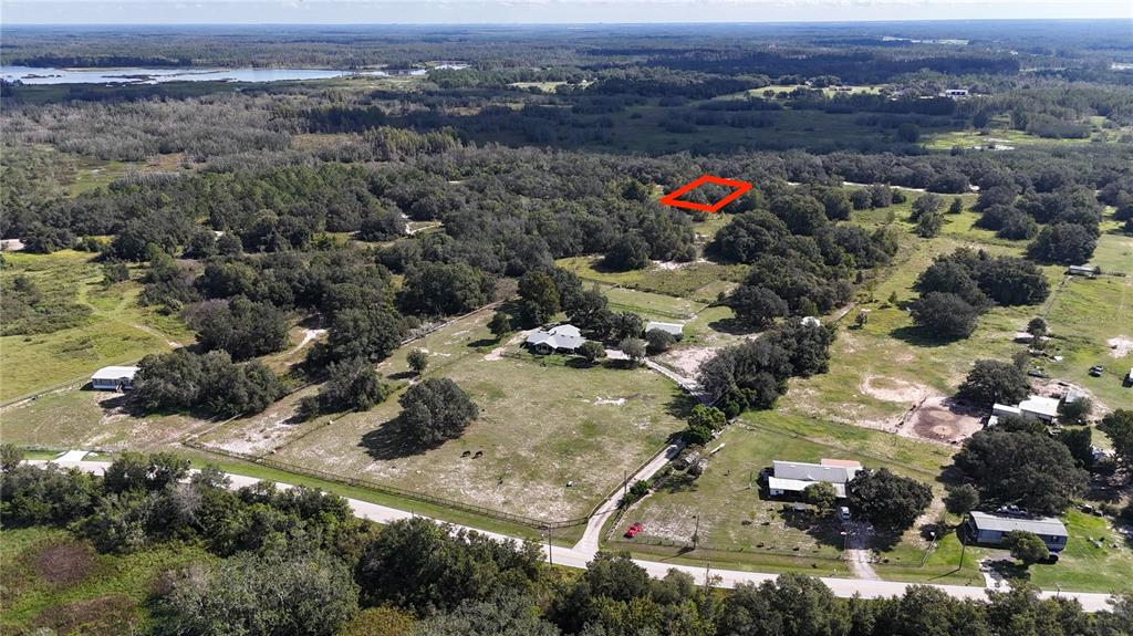 An aerial view shows a rural property with houses, pastures, and a highlighted wooded area — EVANS ROAD, POLK CITY, FL