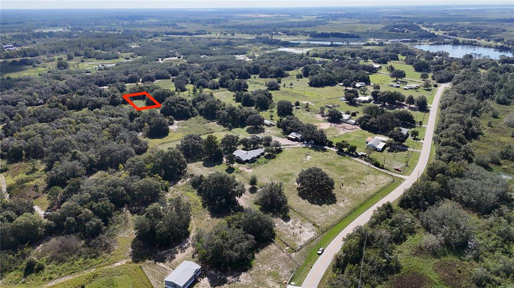 An aerial view shows a rural landscape with a red-outlined plot of land — EVANS ROAD, POLK CITY, FL