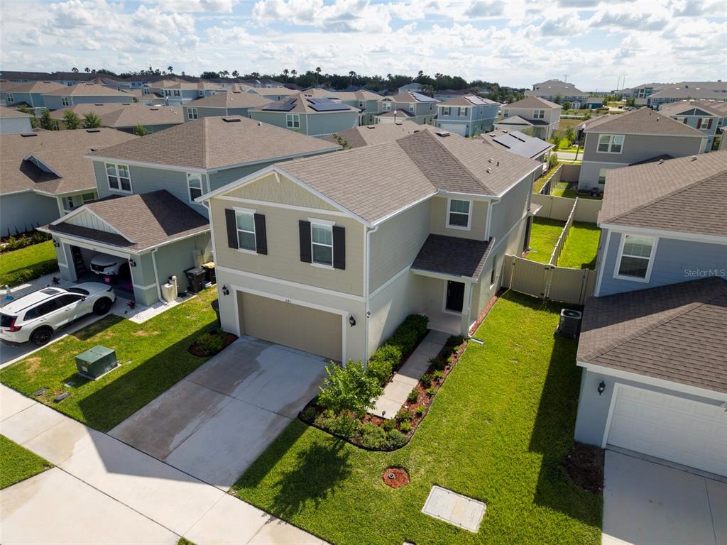 A two-story suburban house with beige siding, a two-car garage, and a front walkway — 1643 DELIGHTFUL DRIVE, DAVENPORT, FL