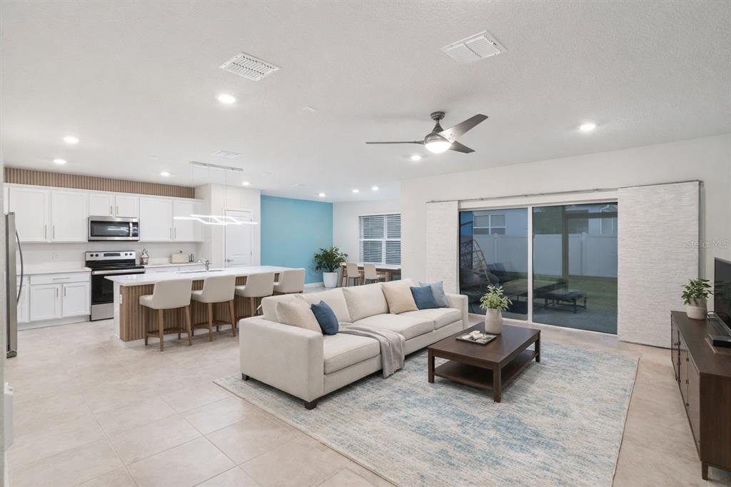 An aerial view shows a two-story suburban house with a tan garage and green siding — 1643 DELIGHTFUL DRIVE, DAVENPORT, FL