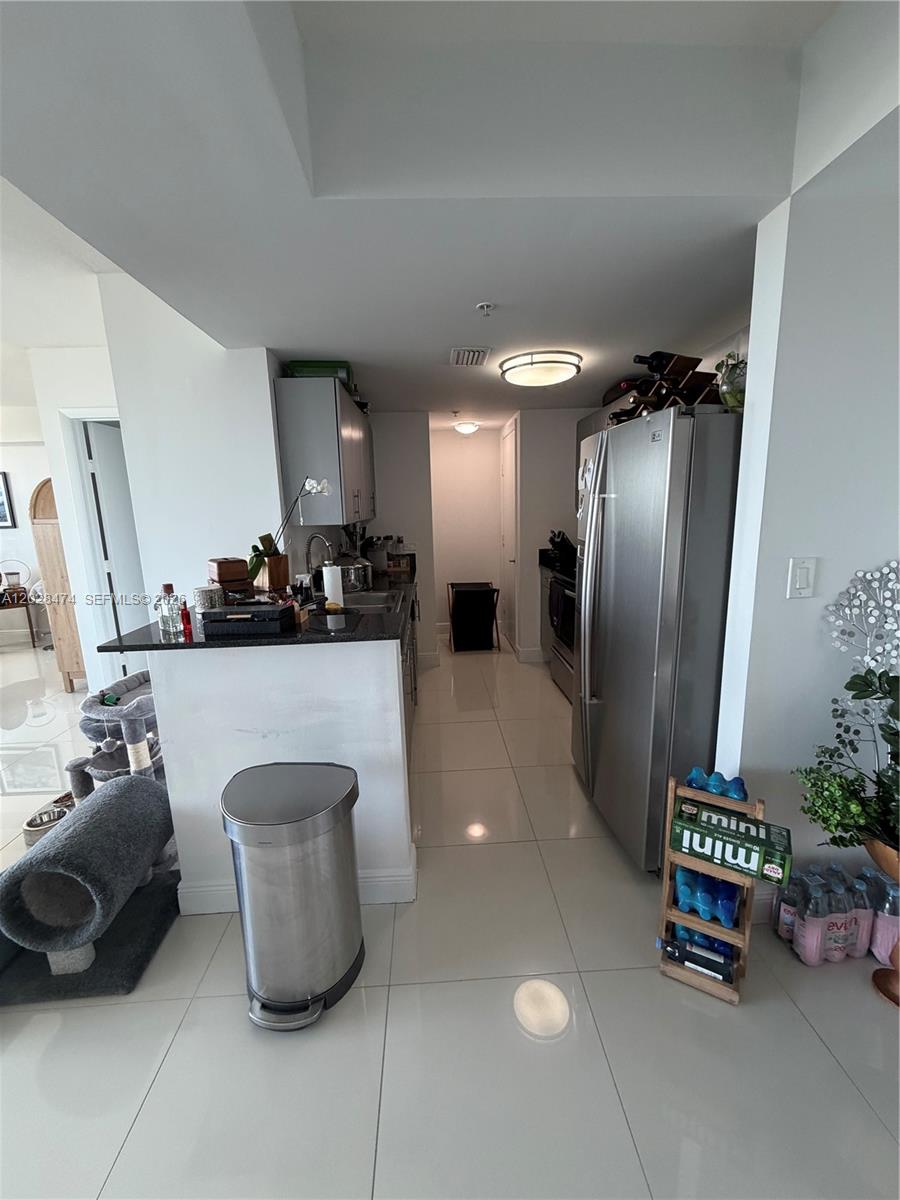 A kitchen features stainless steel appliances, white cabinets, dark countertops, and light tile flooring — 1871 NW S River Dr # 1502, Miami FL 33125, MIAMI, FL