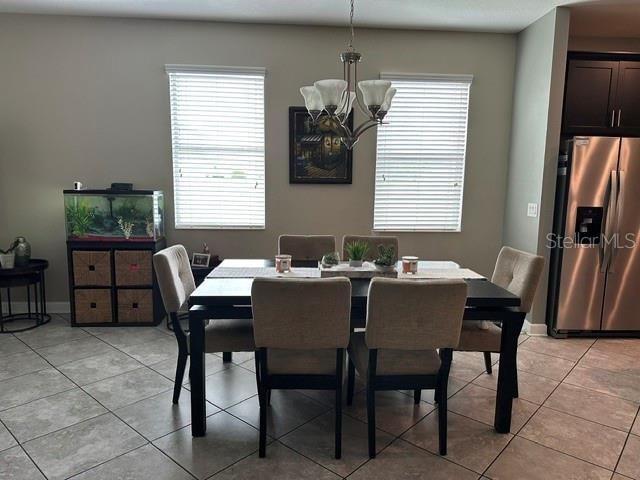 A dining area features a dark wood table with six upholstered chairs under a chandelier — 14072 GOLD BRIDGE DRIVE, ORLANDO, FL