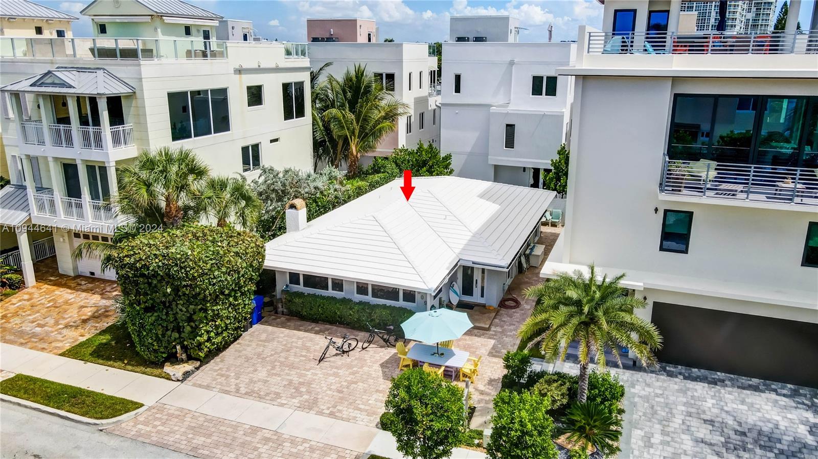 An aerial view shows a white single-story house with a hip roof between two taller buildings — 309 Oak St, Hollywood FL 33019, HOLLYWOOD, FL
