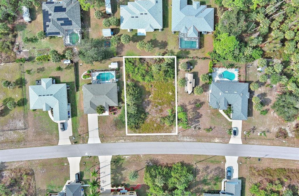 An aerial view shows a vacant rectangular lot situated between two houses with swimming pools — SADNET LANE, NORTH PORT, FL