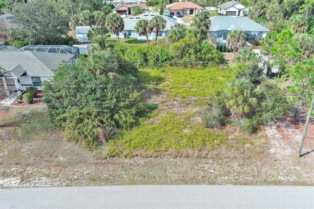 An aerial view of a vacant, overgrown residential lot situated between two houses — SADNET LANE, NORTH PORT, FL