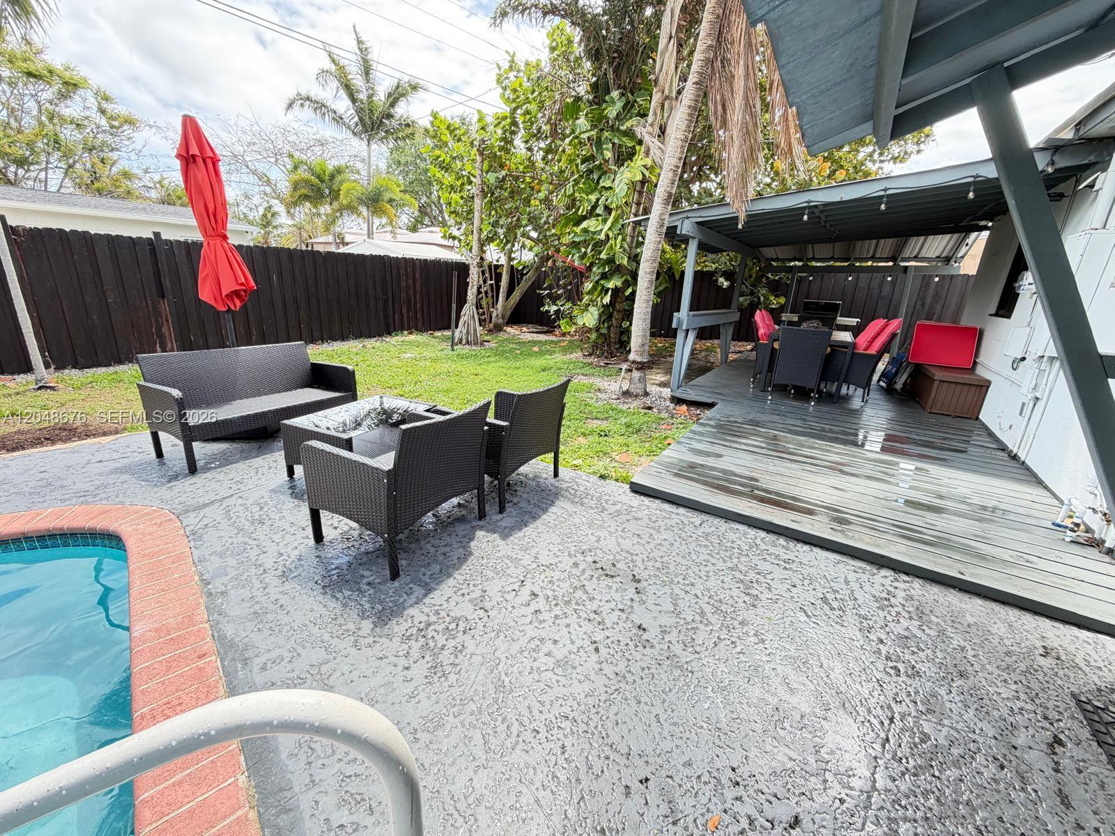 An aerial view of a house with a brown roof, swimming pool, and lush landscaping — 3360 NE 12th Ter, Pompano Beach FL 33064, POMPANO BEACH, FL