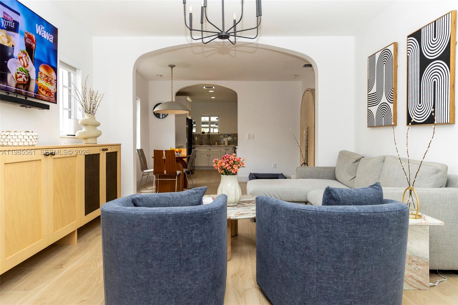 A living room with two blue armchairs, a gray sectional, and an arched entryway — 2397 SW 13th St, Miami FL 33145, MIAMI, FL