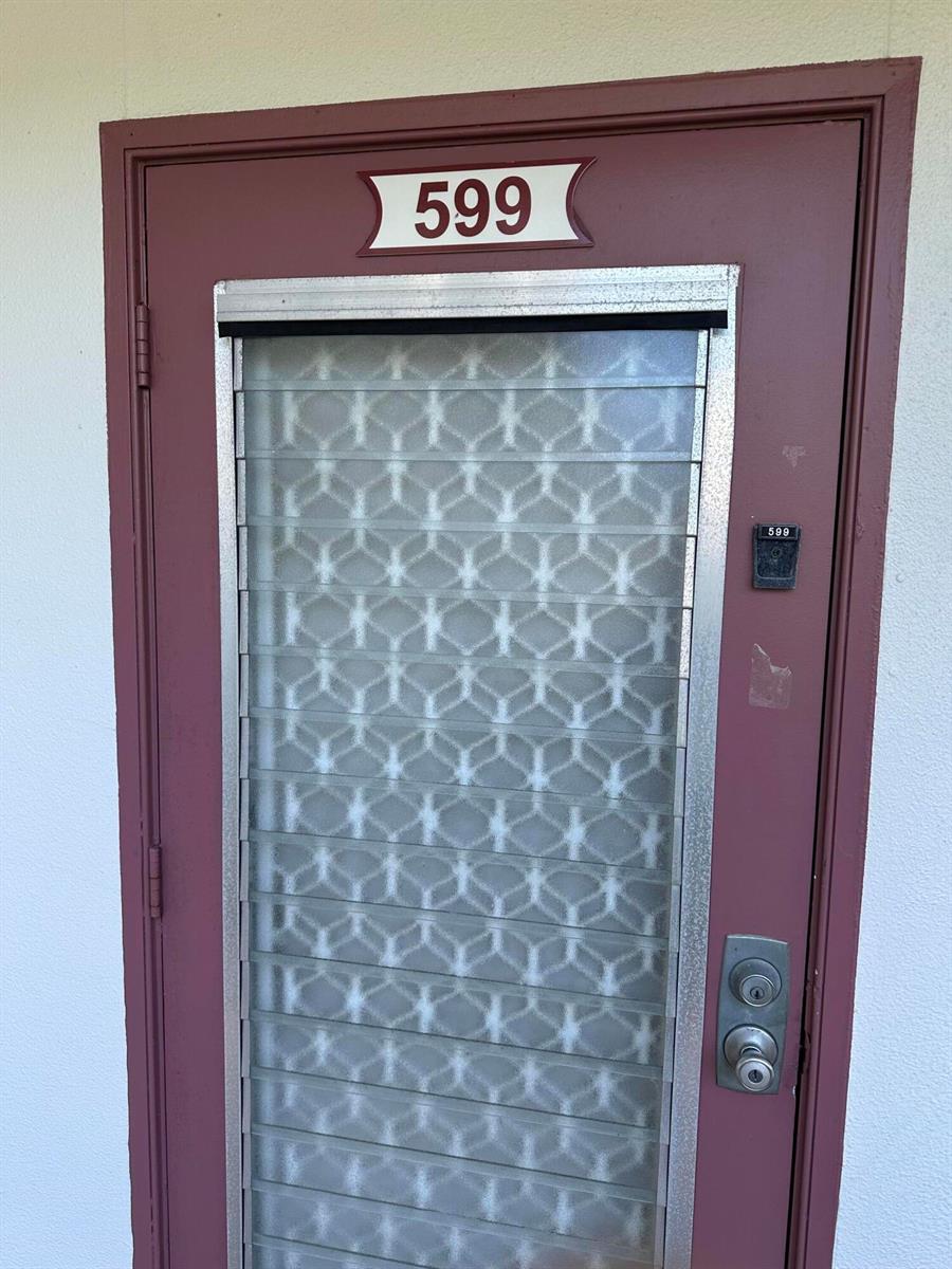 A maroon exterior door with a louvered glass window and the number 599 — 599 Fanshaw O, Boca Raton FL 33434, BOCA RATON, FL