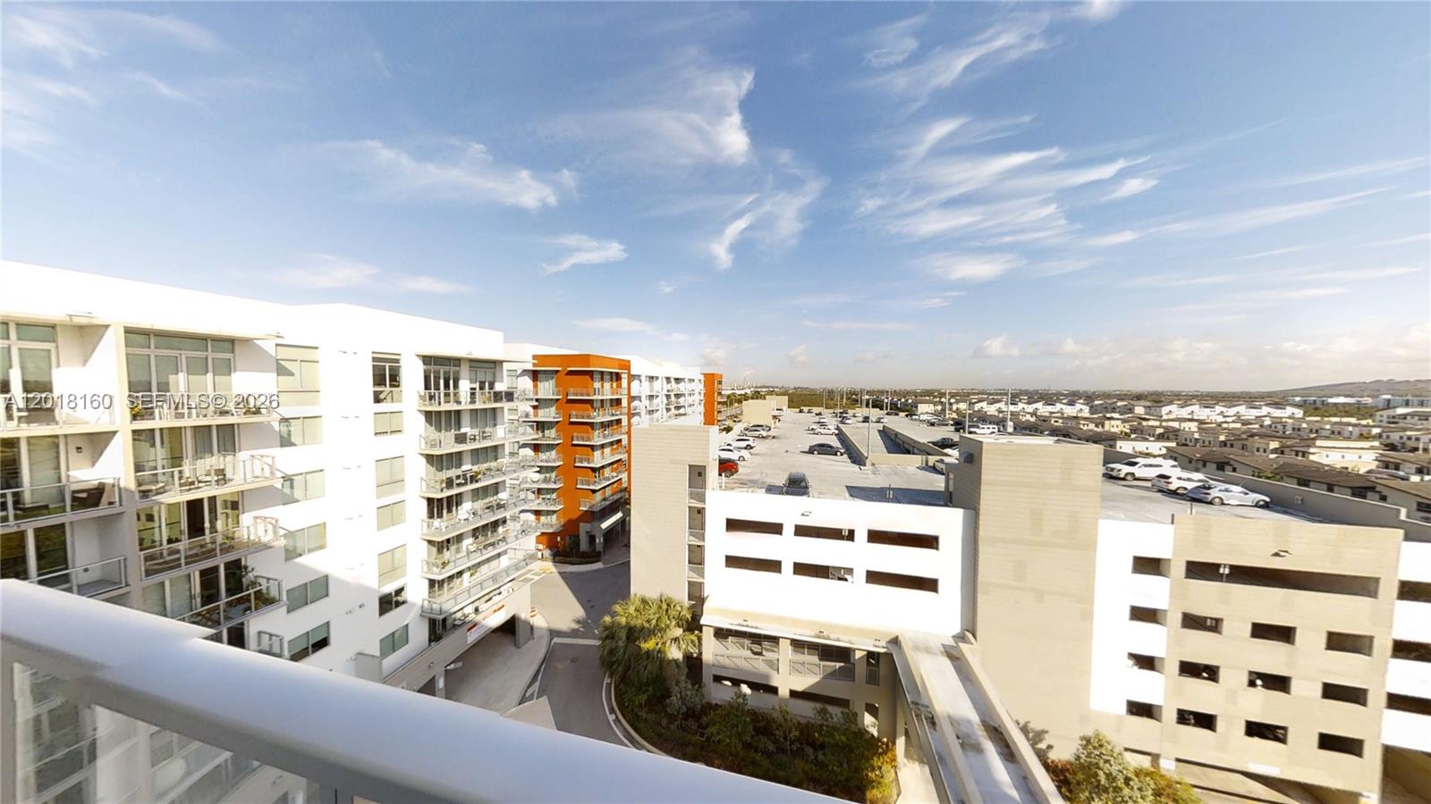 An elevated view shows a modern apartment complex with balconies overlooking a parking garage — 7825 NW 107th Ave # 821, Doral FL 33178, DORAL, FL