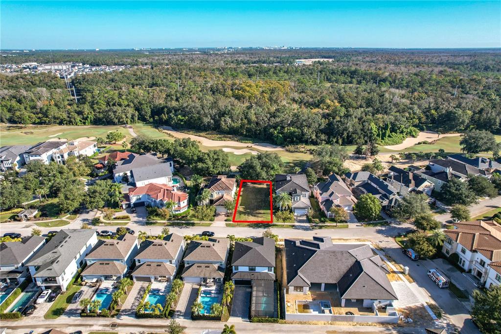 An aerial view shows a vacant rectangular lot situated between two houses in a residential neighborhood — 7455 GATHERING DRIVE, KISSIMMEE, FL