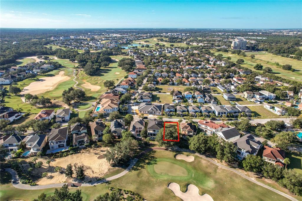 An aerial view shows a vacant residential lot outlined in red within a golf course community — 7455 GATHERING DRIVE, KISSIMMEE, FL