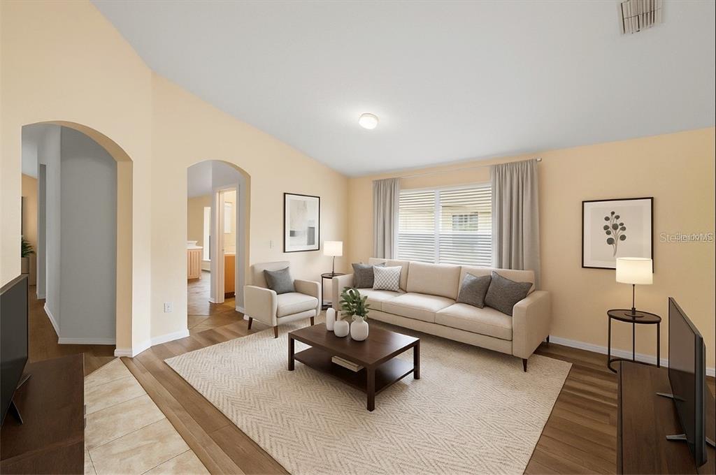 A living room features a beige sofa, armchair, coffee table, and light-colored walls — 3152 WOOD ROSE WAY, DELTONA, FL