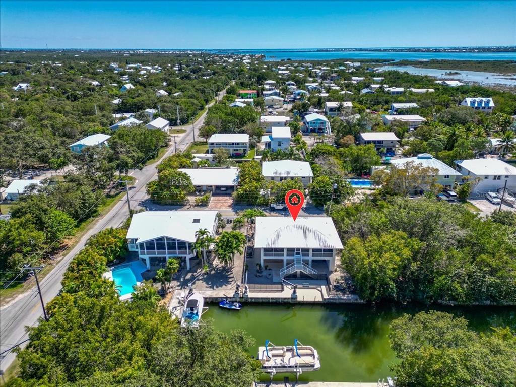 An aerial view shows two waterfront houses with pools and boat docks along a canal — 29051 MAGNOLIA LANE, BIG PINE KEY, FL