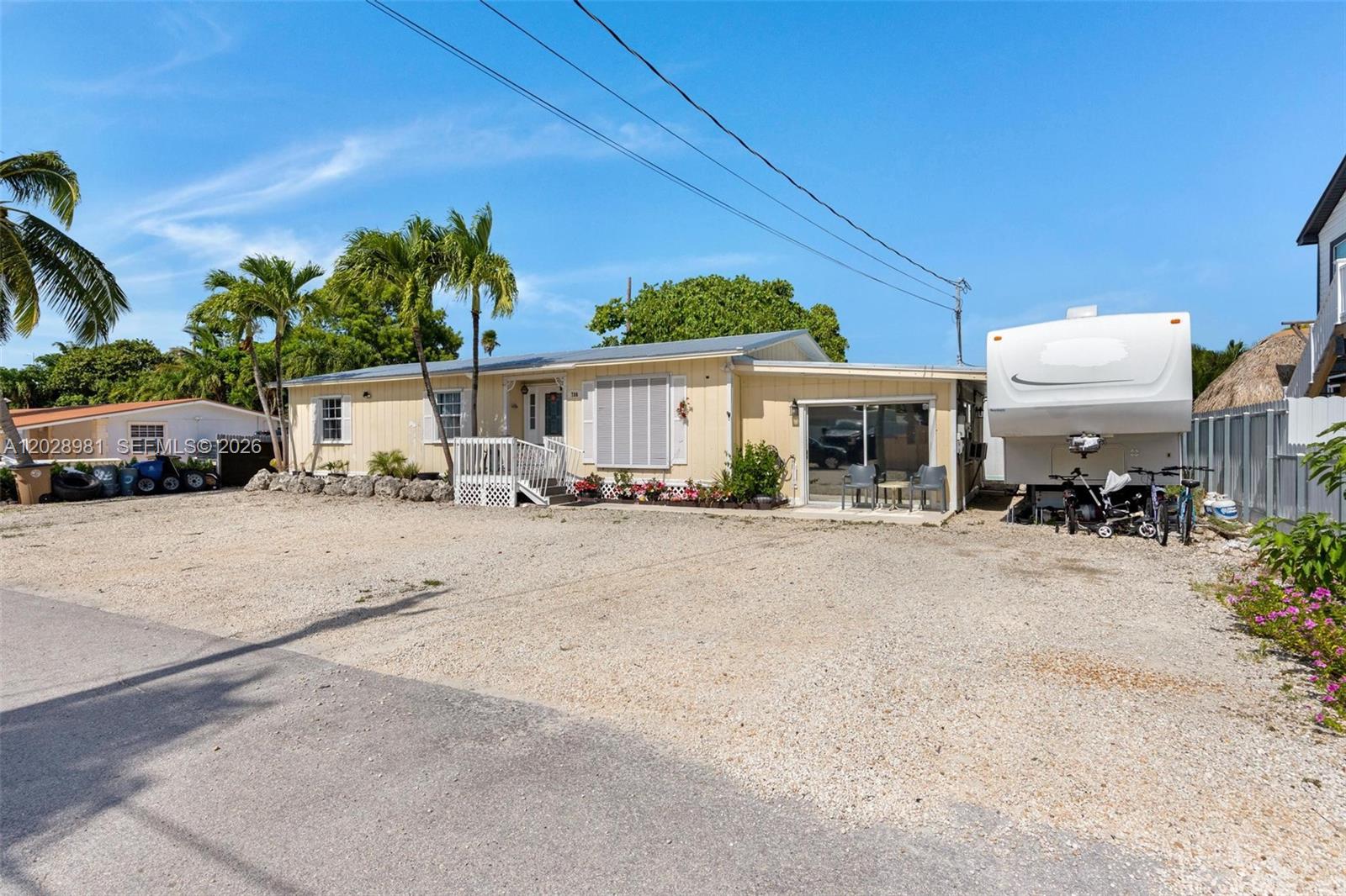 A single-story yellow house with a gravel driveway and a parked RV — 780 95th Street Ocean, Marathon FL 33050, MARATHON, FL