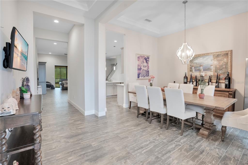 A dining room with a wooden table, upholstered chairs, and tile flooring — 21914 BUTTERFLY KISS DRIVE, LAND O LAKES, FL