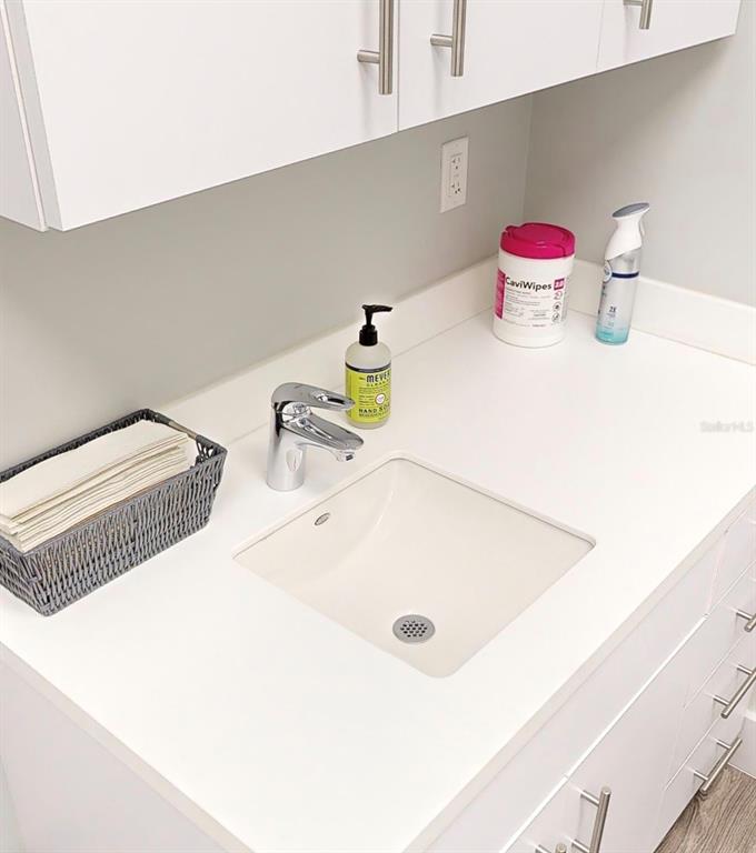 A white bathroom vanity features a square undermount sink, chrome faucet, and white cabinets — 2555 SW 76TH STREET UNIT 110, GAINESVILLE, FL