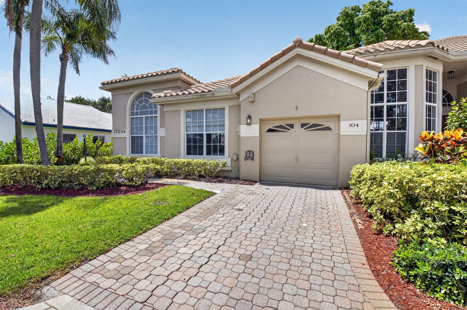 A beige single-story house with a paved driveway, a garage, and landscaped front yard — 17234 Boca Boulevard # 104, Boca Raton FL 33487, BOCA RATON, FL
