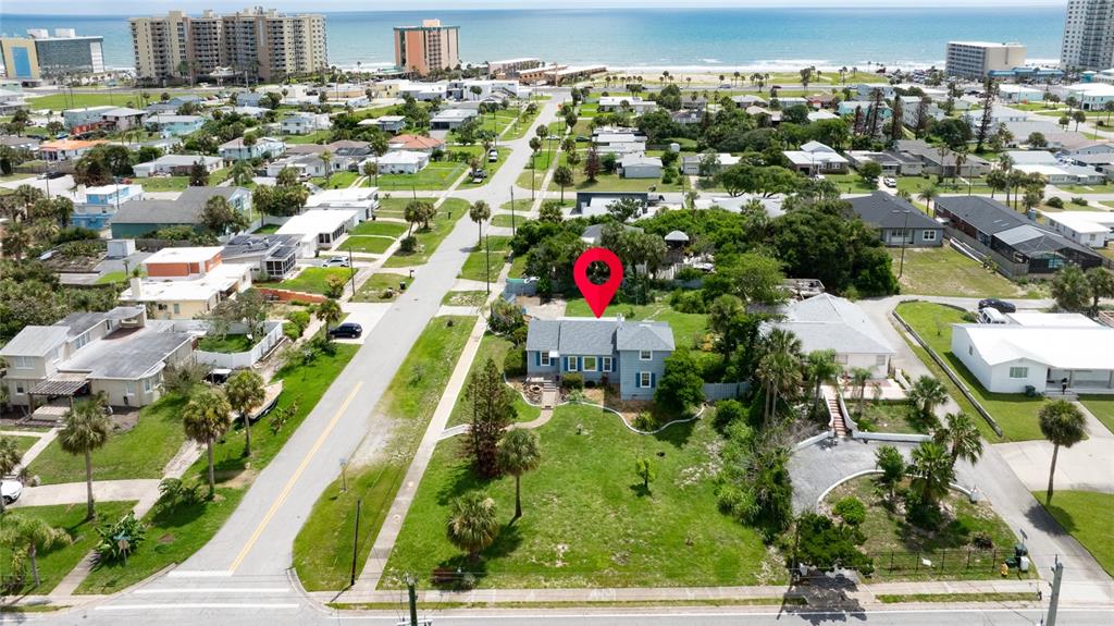 An aerial view shows a blue house with a red location pin on a lot — 2045 S PENINSULA DRIVE, DAYTONA BEACH, FL