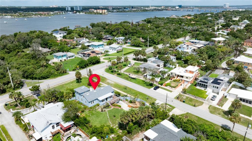 An aerial view shows a light blue house with a red location pin on it — 2045 S PENINSULA DRIVE, DAYTONA BEACH, FL