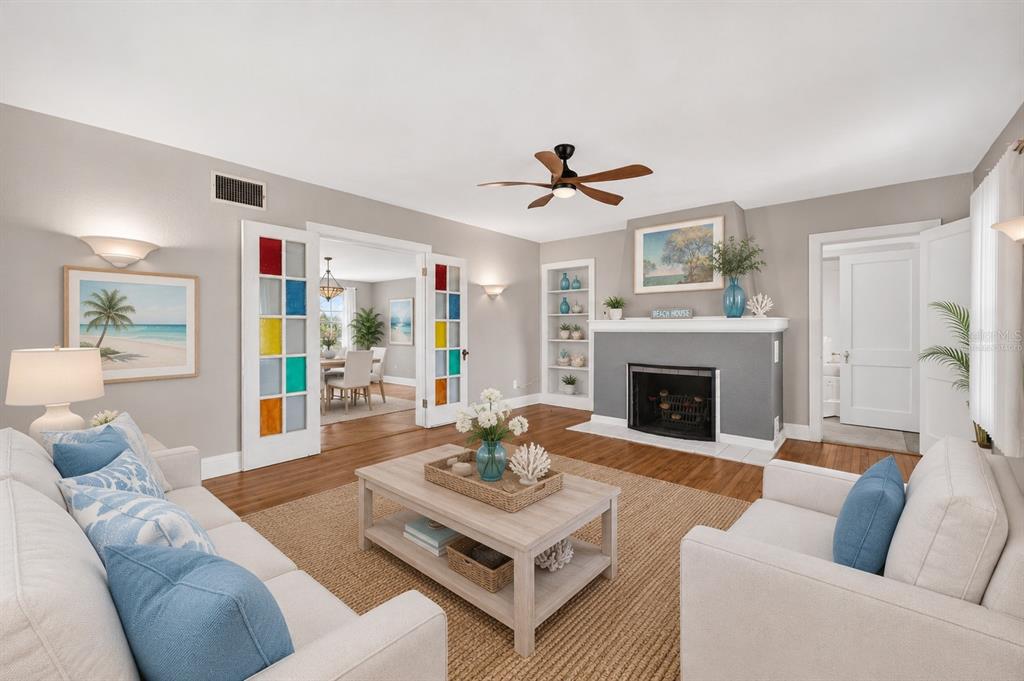 A living room features a fireplace, stained glass French doors, and light-colored furniture — 2045 S PENINSULA DRIVE, DAYTONA BEACH, FL