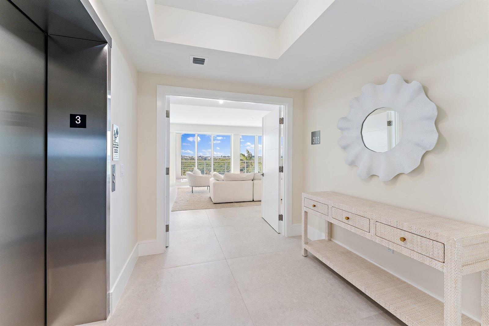 A hallway features a stainless steel elevator, a white console table, and a mirror — 1 S Coastal Way # 3030, Jupiter FL 33477, JUPITER, FL