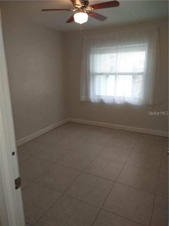 A bedroom with light-colored walls, large floor tiles, and a ceiling fan — 2155 TEMPLE STREET, SARASOTA, FL