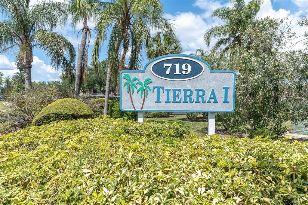 A sign reading 719 TIERRA I stands in front of palm trees and landscaping — 719 PINELLAS BAYWAY S UNIT 110, TIERRA VERDE, FL