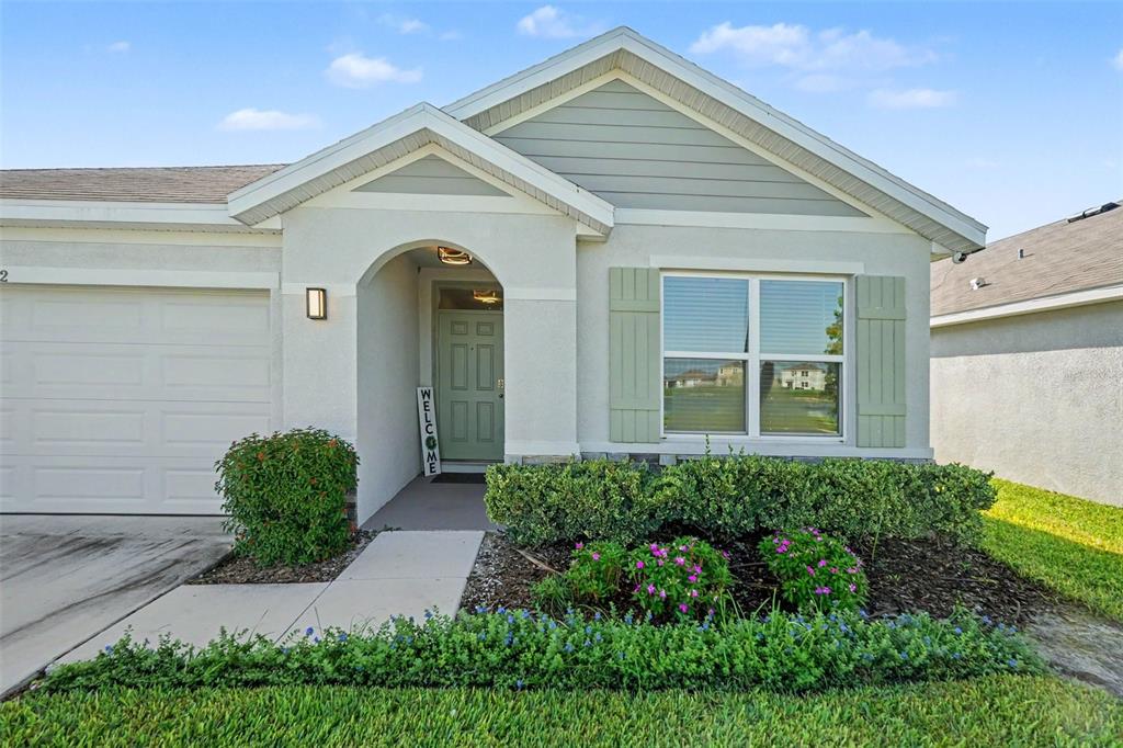 A single-story house exterior features a garage, a covered entryway, and a front garden — 10792 QUAIL GROVE WAY, SAN ANTONIO, FL