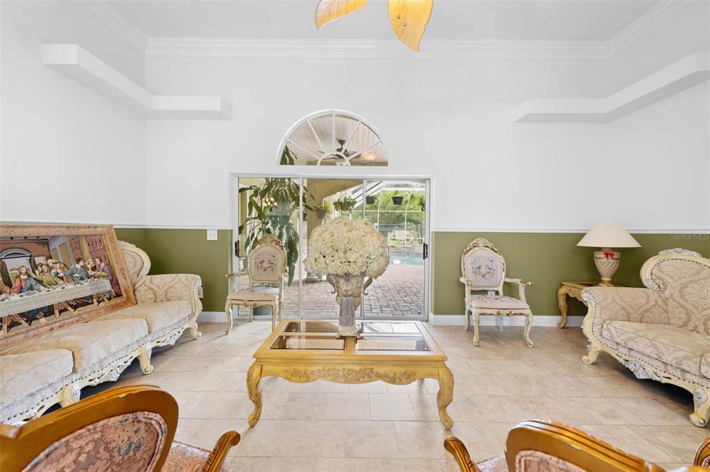 A living room features two sofas, two armchairs, a coffee table, and a sliding glass door — 7393 ROYAL OAK DRIVE, SPRING HILL, FL