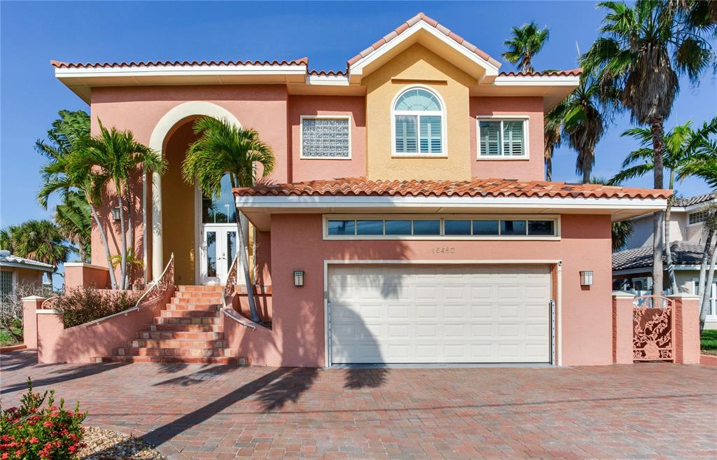 A covered balcony with tile flooring, wicker furniture, and a view of the water — 16480 REDINGTON DRIVE, REDINGTON BEACH, FL