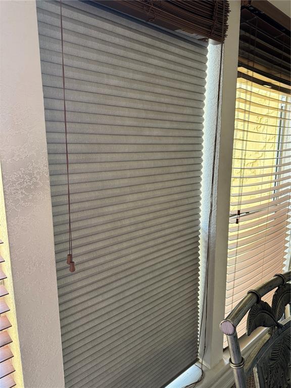 A window with grey pleated shades and brown wood blinds is visible in a room — 3453 CLARK UNIT 252, SARASOTA, FL