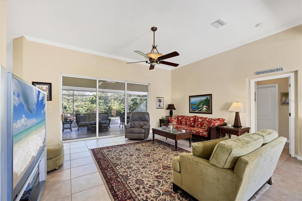 A living room with tile floors, a ceiling fan, and a sliding door to a patio — 9350 GULFSTREAM BOULEVARD, ENGLEWOOD, FL