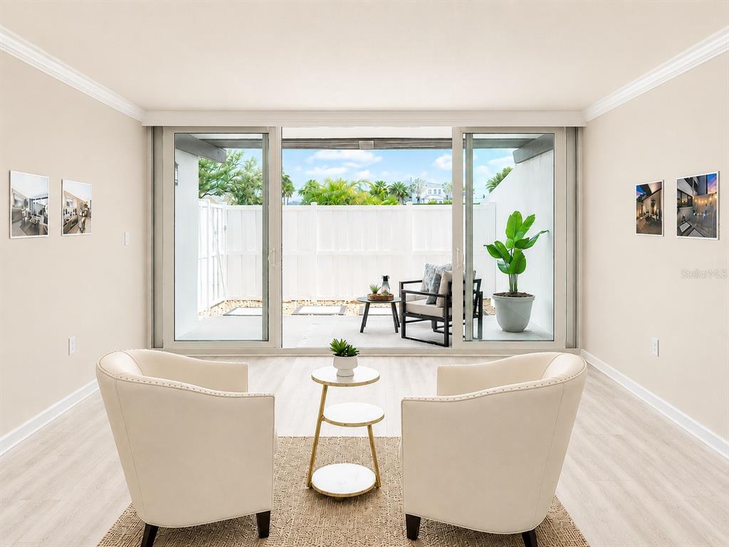 A living room features two cream armchairs, a tiered side table, and sliding glass doors — 450 TREASURE ISLAND CAUSEWAY UNIT 102, TREASURE ISLAND, FL