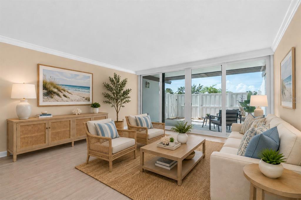 A living room features light wood furniture, a beige sofa, two armchairs, and sliding glass doors — 450 TREASURE ISLAND CAUSEWAY UNIT 102, TREASURE ISLAND, FL