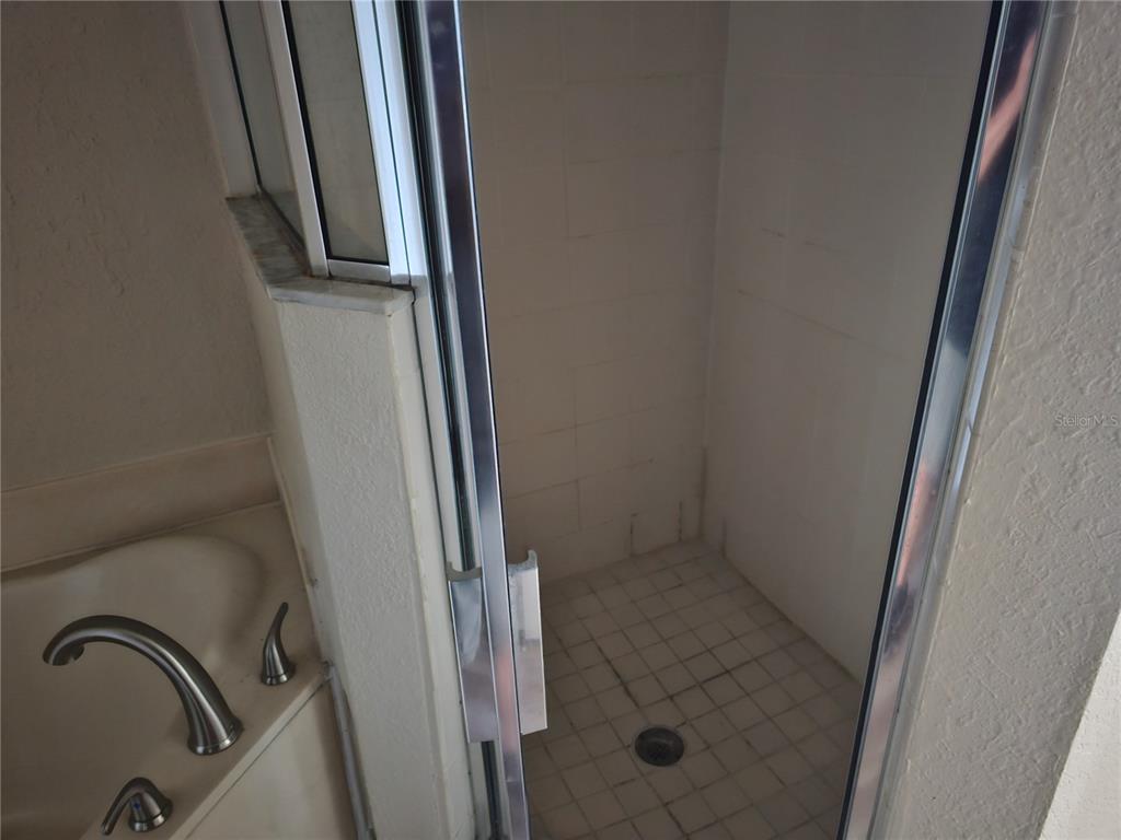 A white stacked washer and dryer unit is installed inside a small closet — 3201 LAKE MARION RESORT CIRCLE, POINCIANA, FL