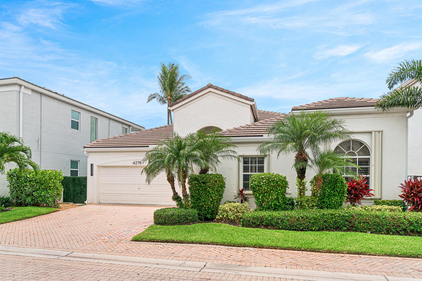 A single-story house with a beige stucco exterior, a tiled roof, and a brick driveway — 4278 NW 65th Road, Boca Raton FL 33496, BOCA RATON, FL
