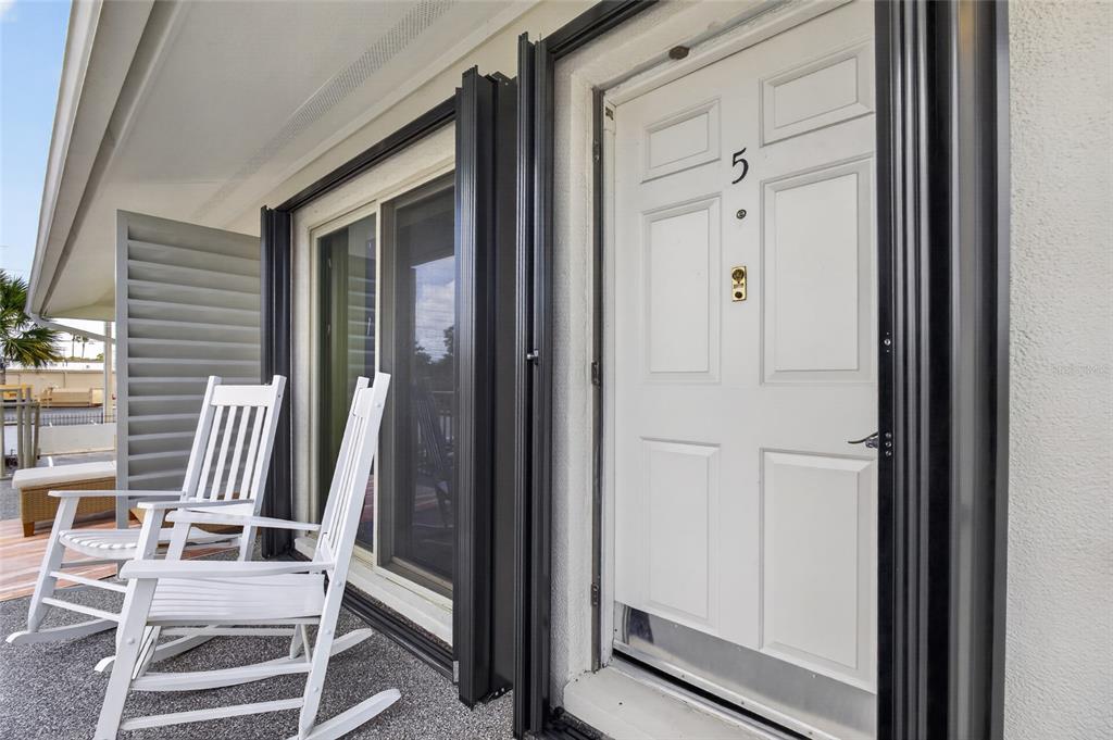 A white front door with the number five and two white rocking chairs on a patio — 1935 CONWAY ROAD UNIT L5, ORLANDO, FL
