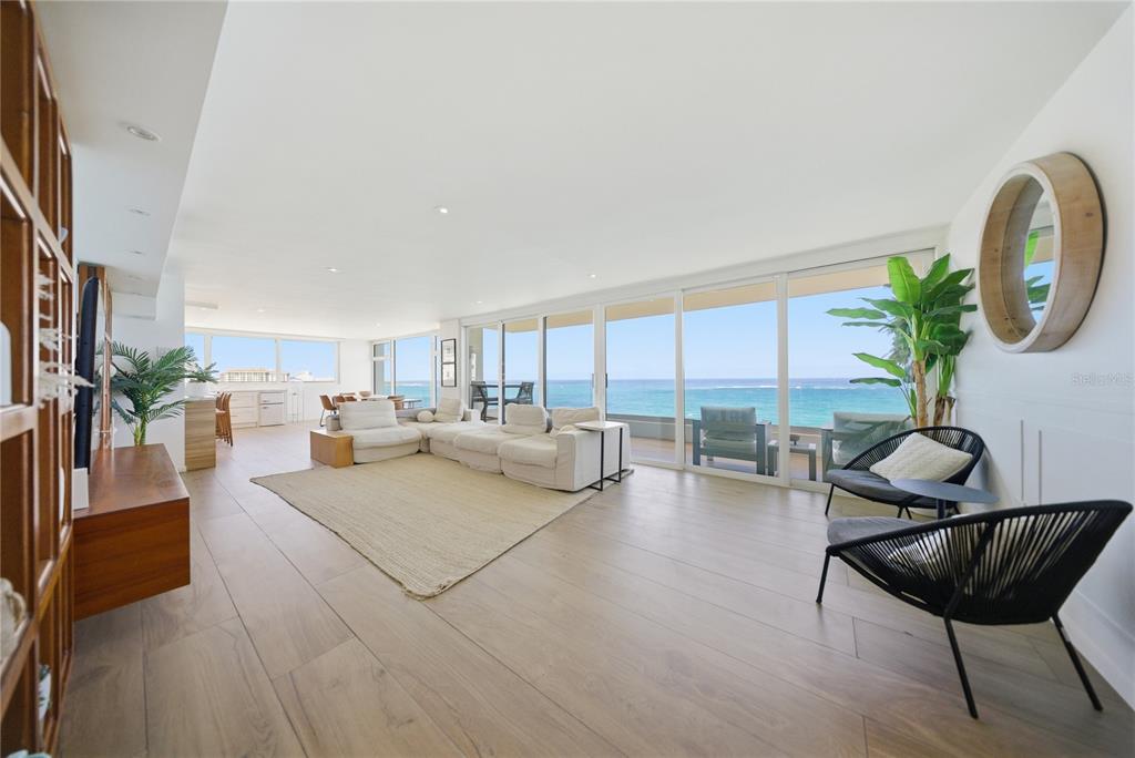 A bright, open-concept living room features light wood floors, a large sectional, and ocean views — 1 CERVANTES UNIT 9 PH, SAN JUAN, PR