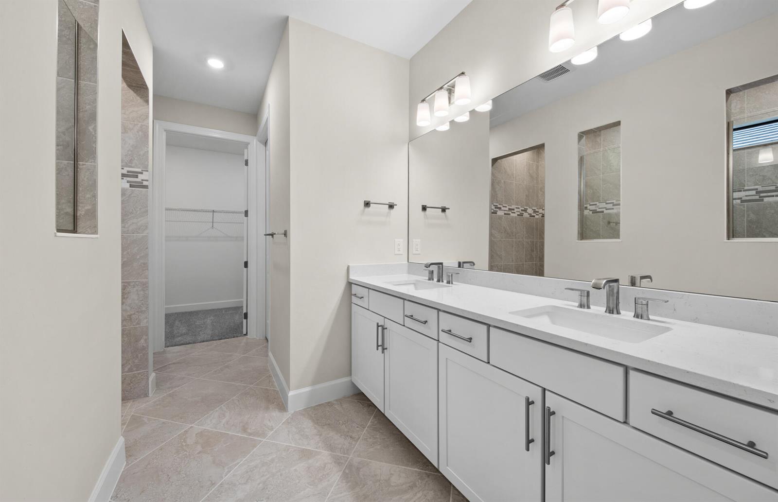 A bathroom features a white double vanity, a large mirror, and tile flooring — 3922 E Hampton Circle, FL 33920, FL